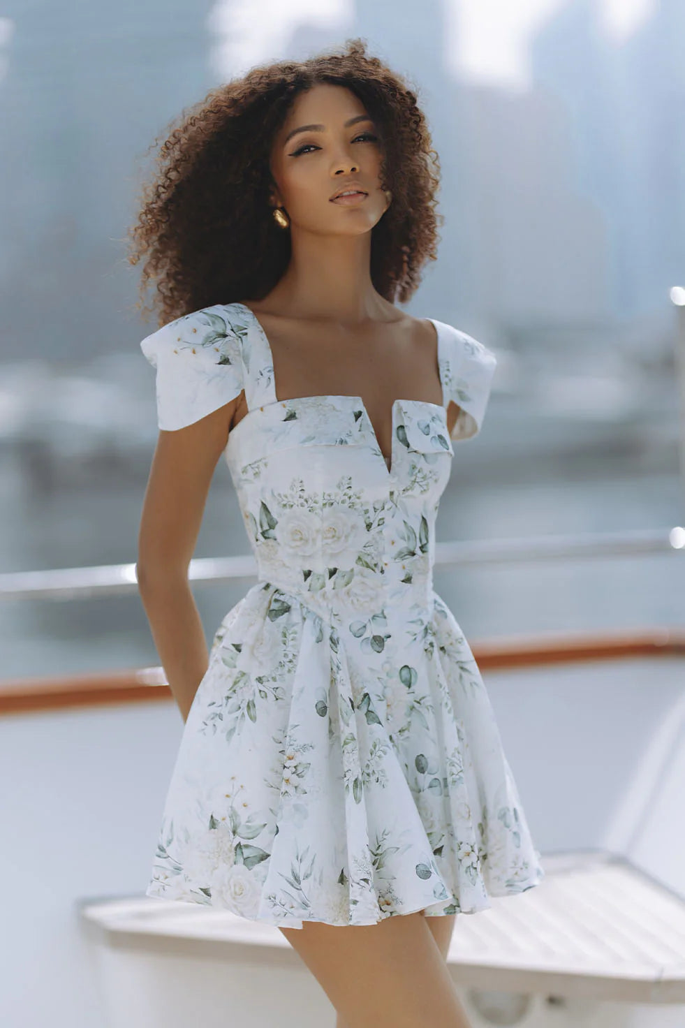 Woman wearing white floral mini dress with puff sleeves on balcony — Chic Le Frique | Endless UAE