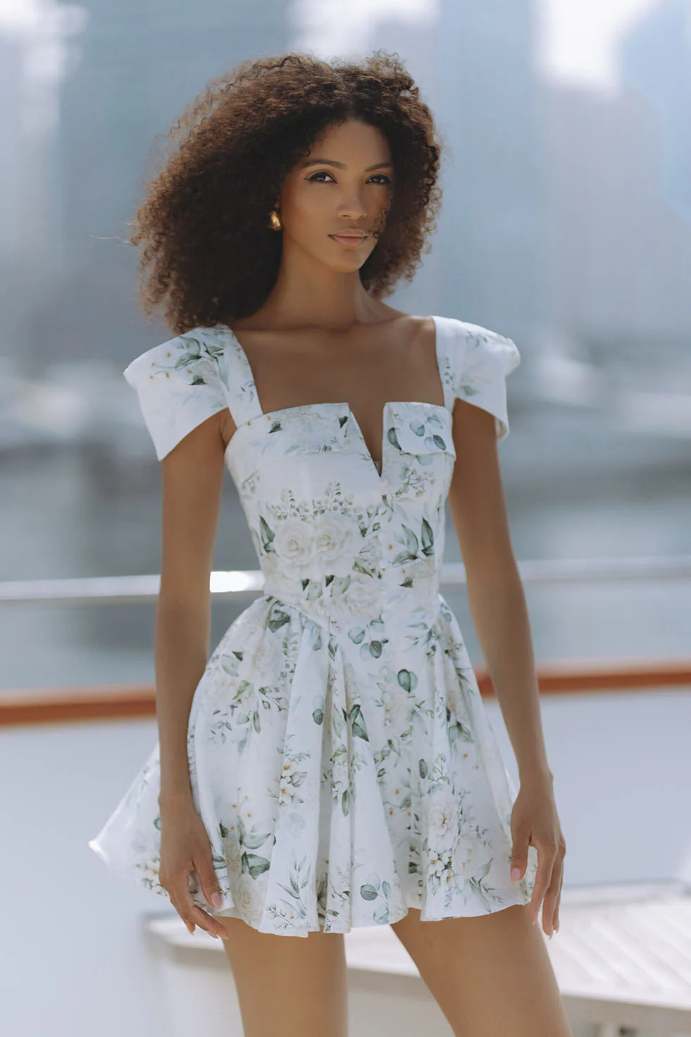 Woman wearing white floral mini dress with puff sleeves on balcony — Chic Le Frique | Endless UAE