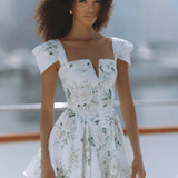 Woman wearing white floral mini dress with puff sleeves on balcony — Chic Le Frique | Endless UAE