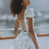 Woman wearing white floral mini dress with puff sleeves on balcony — Chic Le Frique | Endless UAE