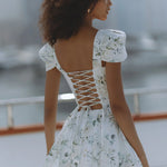 Woman wearing white floral mini dress with puff sleeves on balcony — Chic Le Frique | Endless UAE