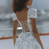 Woman wearing white floral mini dress with puff sleeves on balcony — Chic Le Frique | Endless UAE
