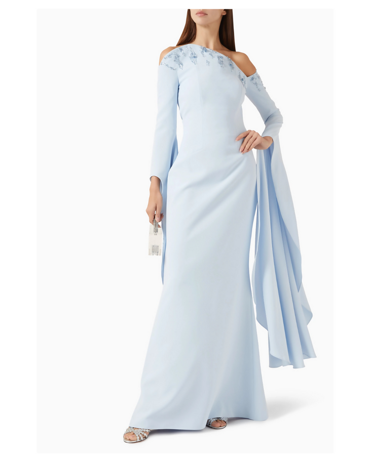 Light blue evening gown with beaded shoulder detail, cold shoulder cutouts, and dramatic flowing cape sleeves — Heva | Endless UAE