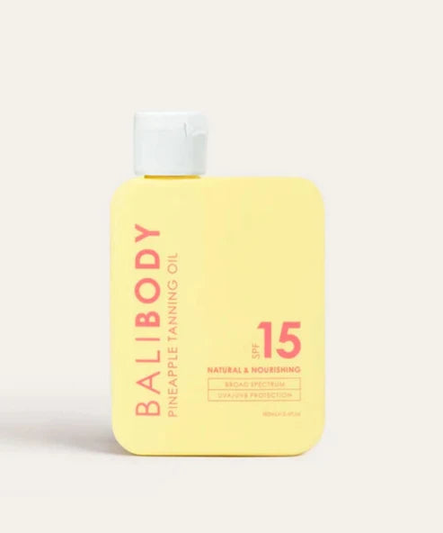 Bali Body Pineapple Tanning Oil SPF15 bottle with white cap on beige background — Powder Beauty | Endless UAE