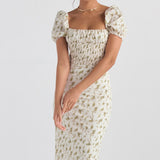 White midi dress with yellow floral print, puff sleeves, and shirred bodice modeled on woman against gray background — House of CB | Endless UAE