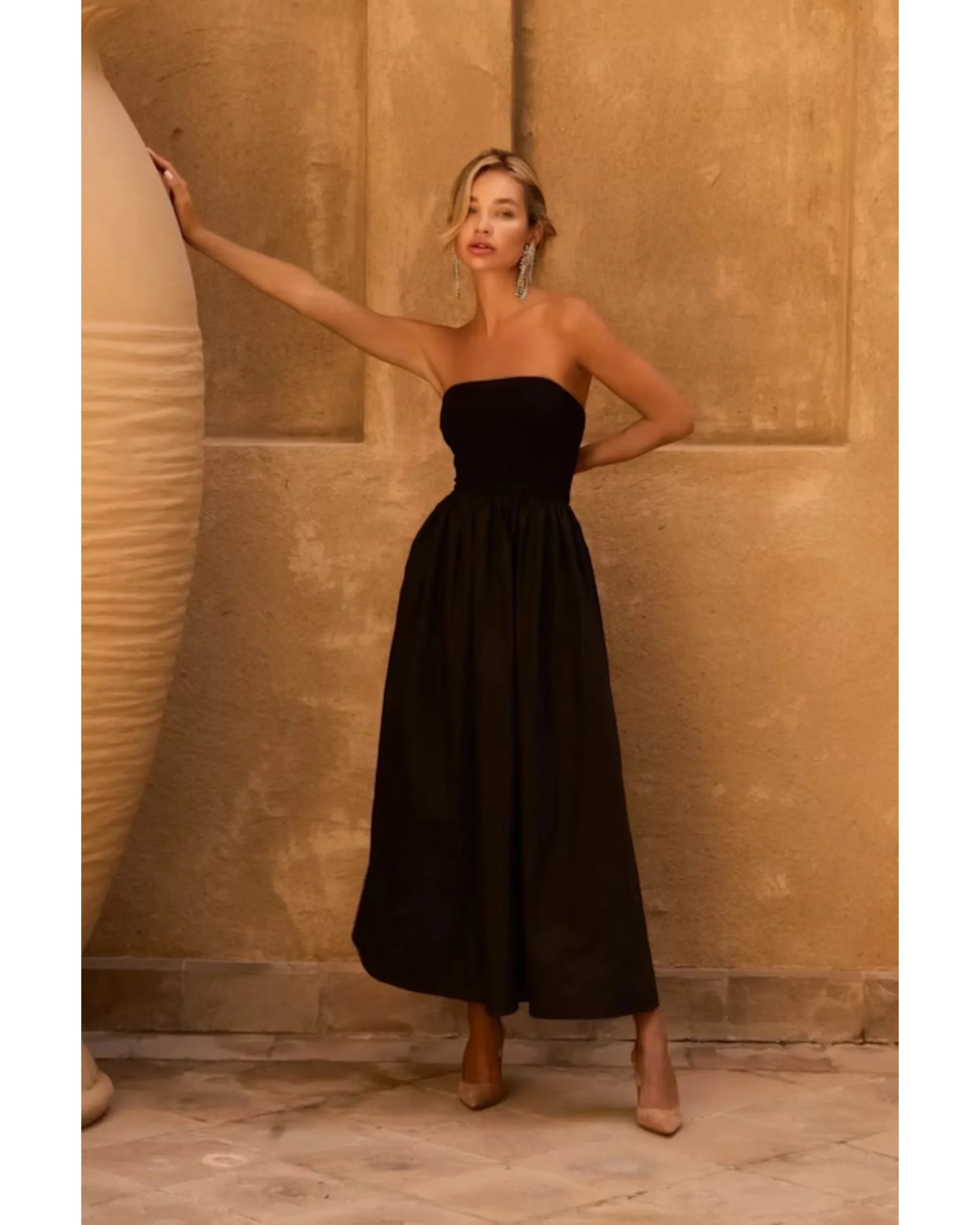 Black strapless midi dress with fitted bodice and flowing skirt, styled with nude heels — Anne Louise Boutique | Endless UAE