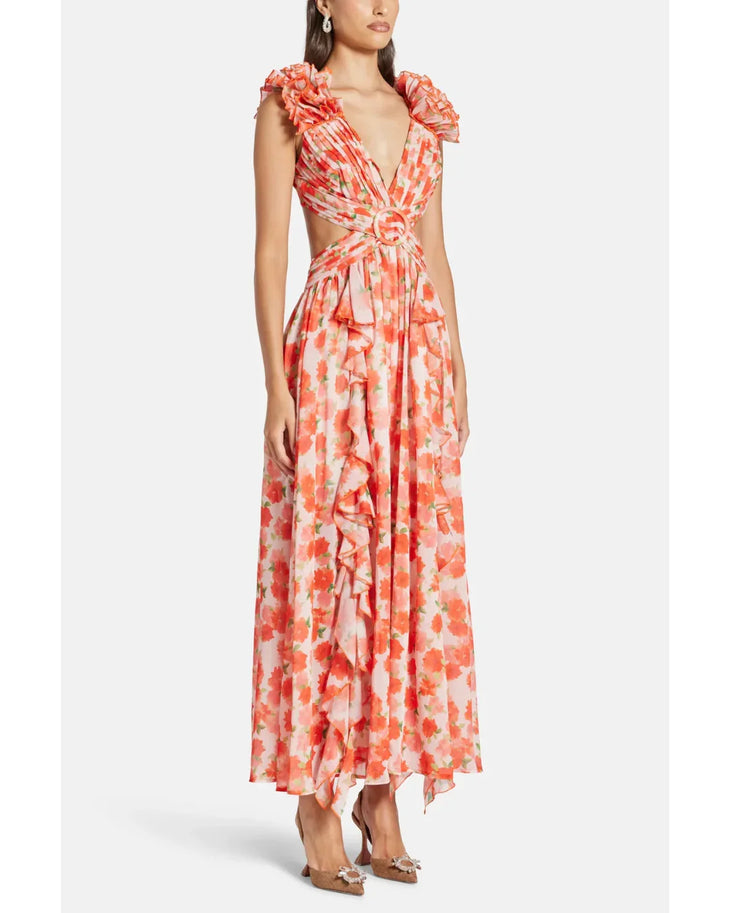 Woman wearing a coral floral maxi dress with flutter sleeves and cutout waist detail — Anne Louise Boutique | Endless UAE