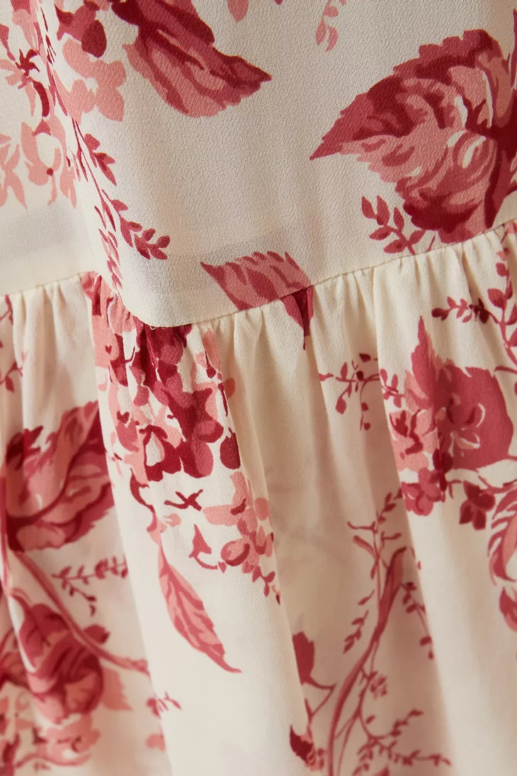 Woman wearing a cream and pink floral maxi dress with spaghetti straps and tiered ruffled hem — Reformation | Endless UAE