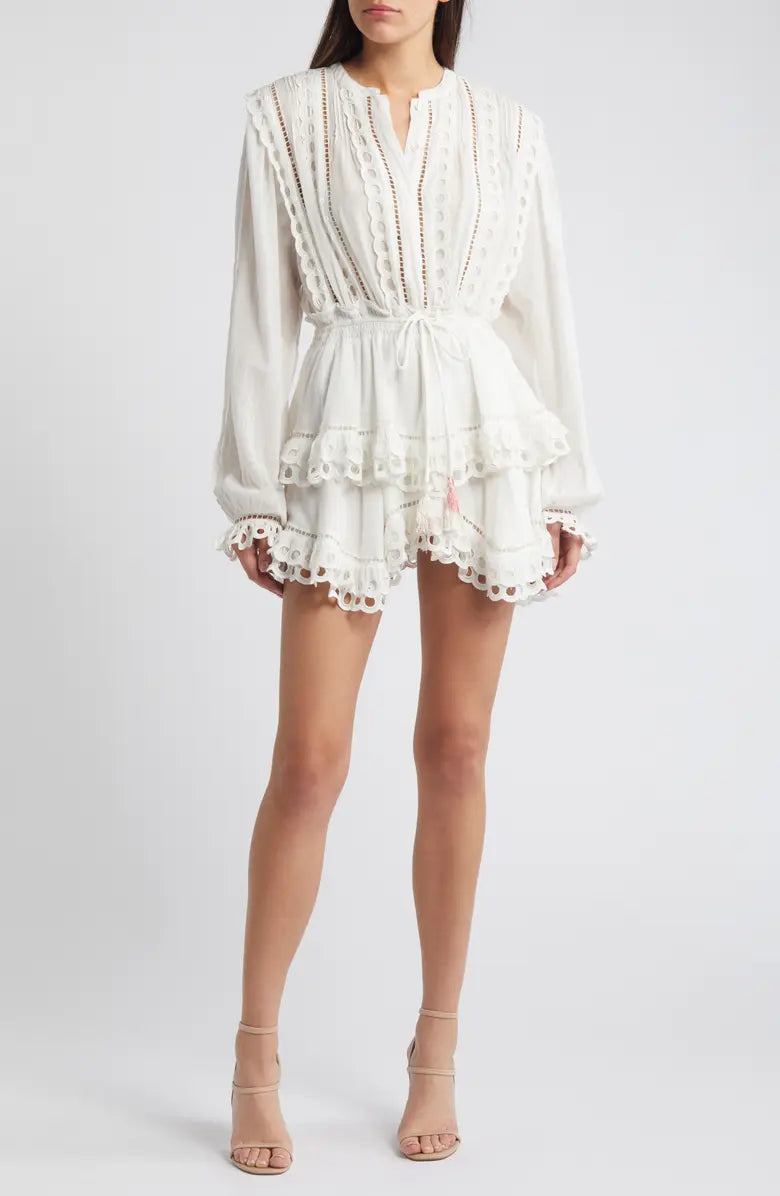 Woman wearing white eyelet cotton mini dress with long sleeves and layered skirt — LoveShackFancy | Endless UAE