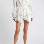 Woman wearing white eyelet cotton mini dress with long sleeves and layered skirt — LoveShackFancy | Endless UAE