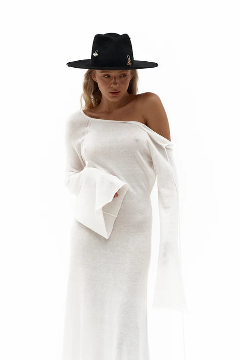 Woman wearing elegant white knit maxi dress with flared sleeves against minimal background — Affluence | Endless UAE
