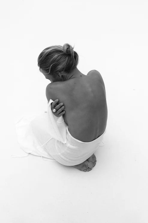 Woman wearing elegant white knit maxi dress with flared sleeves against minimal background — Affluence | Endless UAE