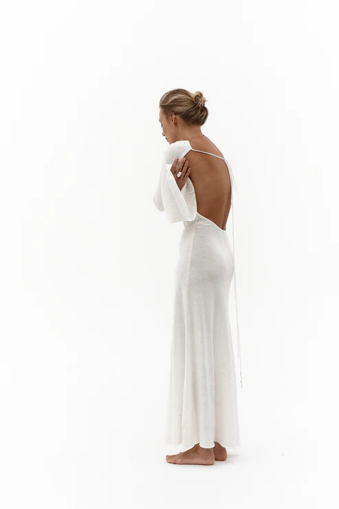 Elegant white backless maxi dress with tie detail, side view showing flowing silhouette — Affluence | Endless UAE