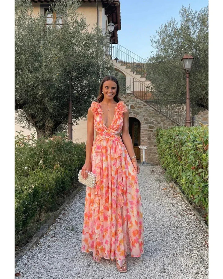 Woman wearing a coral floral maxi dress with flutter sleeves and cutout waist detail — Anne Louise Boutique | Endless UAE