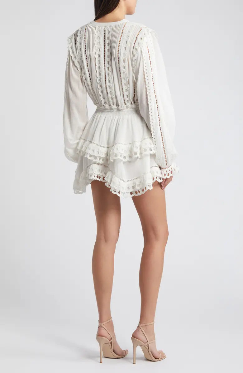 Woman wearing white eyelet cotton mini dress with long sleeves and layered skirt — LoveShackFancy | Endless UAE