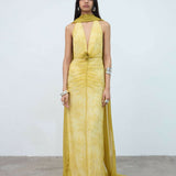 Woman wearing yellow halter maxi dress with deep V-neckline and circular buckle detail — Endless | Endless UAE