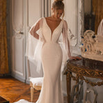 Embellished mermaid wedding dress with flowing cape and plunging neckline — Katy Corso Glen | Endless UAE