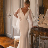 Embellished mermaid wedding dress with flowing cape and plunging neckline — Katy Corso Glen | Endless UAE