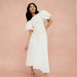 Woman wearing white Siren Drawstring Midi Dress with puffed sleeves and green strappy heels — Aje | Endless UAE
