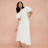 Woman wearing white Siren Drawstring Midi Dress with puffed sleeves and green strappy heels — Aje | Endless UAE