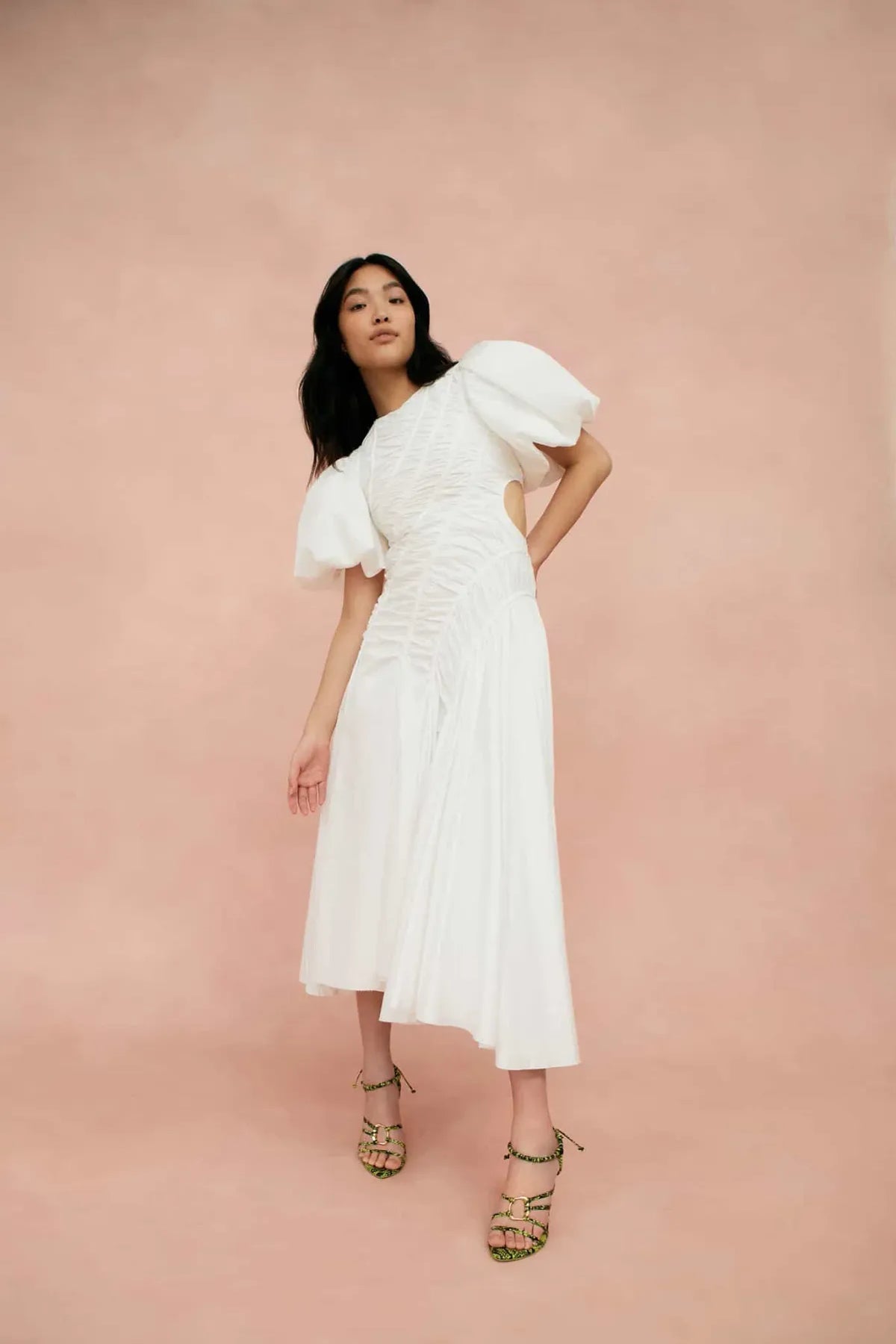 Woman wearing white Siren Drawstring Midi Dress with puffed sleeves and green strappy heels — Aje | Endless UAE