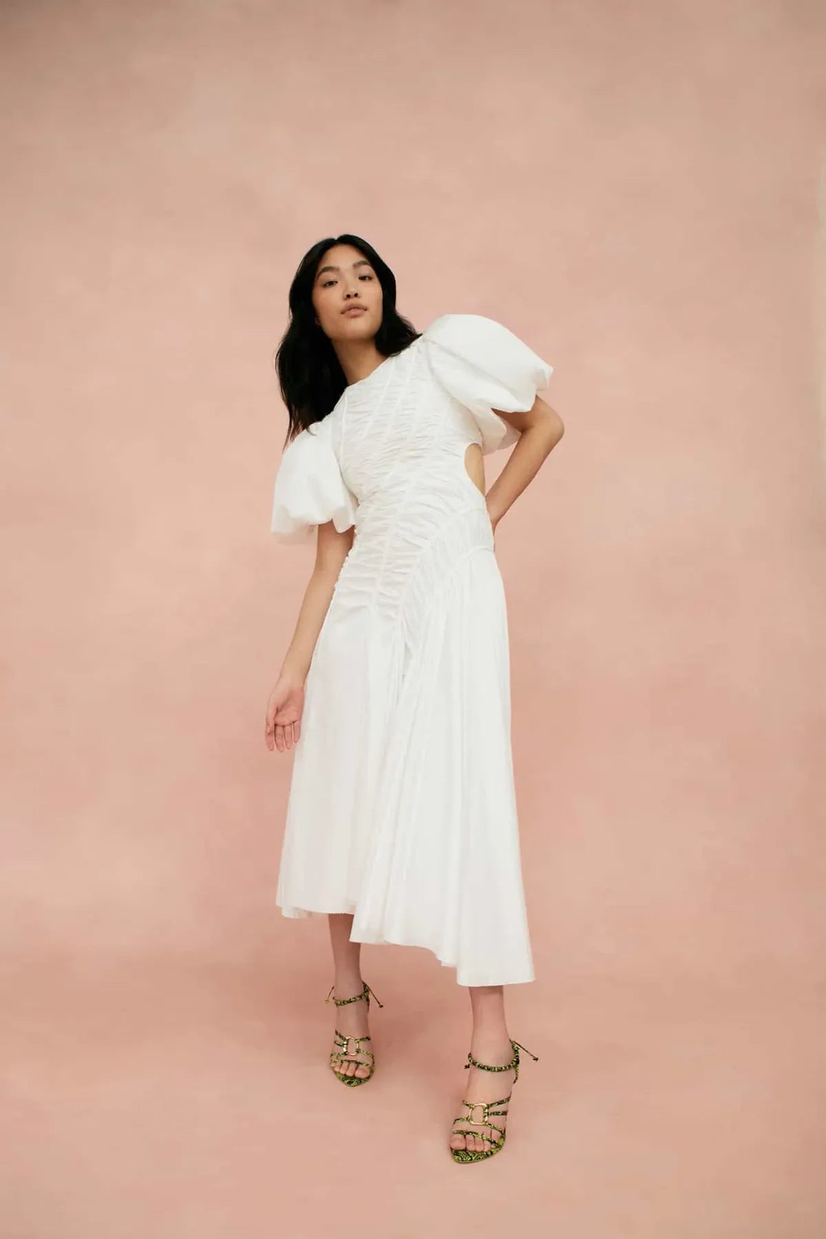 Woman wearing white Siren Drawstring Midi Dress with puffed sleeves and green strappy heels — Aje | Endless UAE