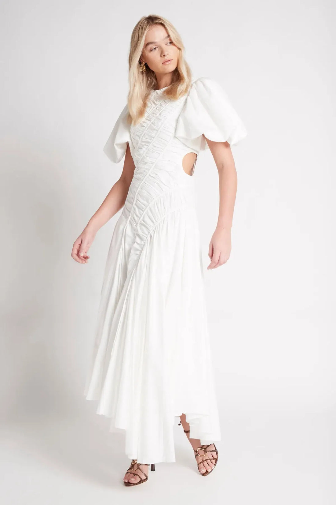 Woman wearing white Siren Drawstring Midi Dress with puffed sleeves and green strappy heels — Aje | Endless UAE
