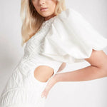 Woman wearing white Siren Drawstring Midi Dress with puffed sleeves and green strappy heels — Aje | Endless UAE