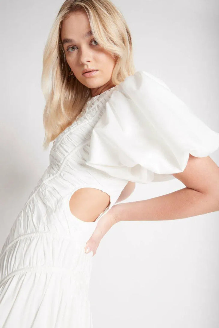 Woman wearing white Siren Drawstring Midi Dress with puffed sleeves and green strappy heels — Aje | Endless UAE
