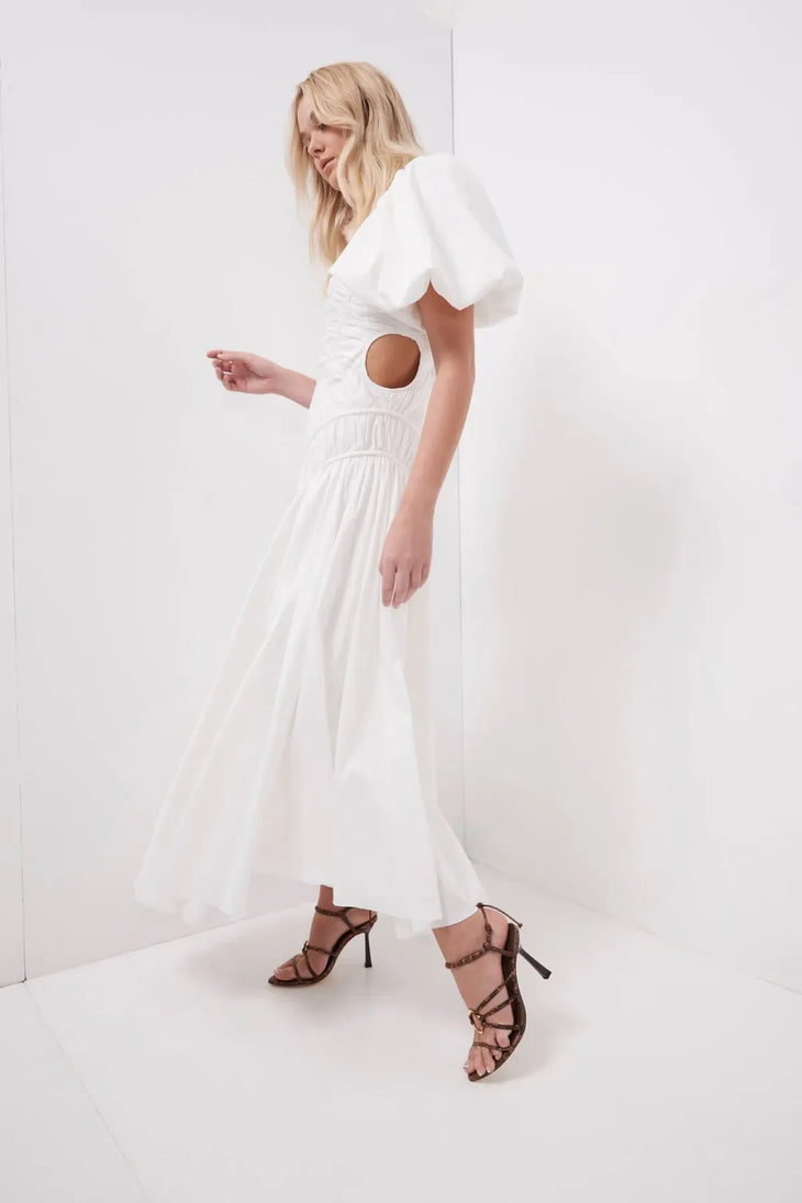 Woman wearing white Siren Drawstring Midi Dress with puffed sleeves and green strappy heels — Aje | Endless UAE