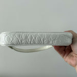 White quilted mini shoulder bag with silver hardware held up against neutral background — By Far | Endless UAE