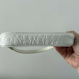 White quilted mini shoulder bag with silver hardware held up against neutral background — By Far | Endless UAE