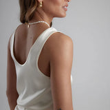 Woman wearing white sleeveless scoop neck tank top with pearl necklace — By Keara | Endless UAE