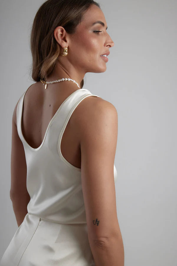 Woman wearing white sleeveless scoop neck tank top with pearl necklace — By Keara | Endless UAE