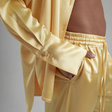 Woman wearing oversized cream silk shirt and matching pants, back view — By Keara | Endless UAE