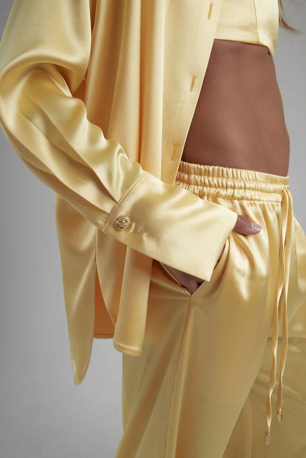 Woman wearing oversized cream silk shirt and matching pants, back view — By Keara | Endless UAE