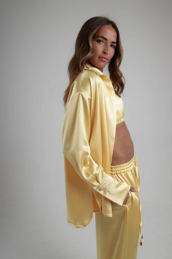 Woman wearing oversized cream silk shirt and matching pants, back view — By Keara | Endless UAE