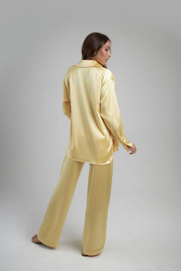 Woman wearing oversized cream silk shirt and matching pants, back view — By Keara | Endless UAE