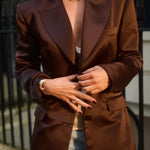 Woman wearing brown structured blazer with peak lapels and button closure paired with distressed jeans — By Keara | Endless UAE