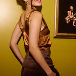 Classic brown mini skirt with elastic waistband, modeled from back view against yellow wall — By Keara | Endless UAE