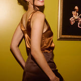 Classic brown mini skirt with elastic waistband, modeled from back view against yellow wall — By Keara | Endless UAE