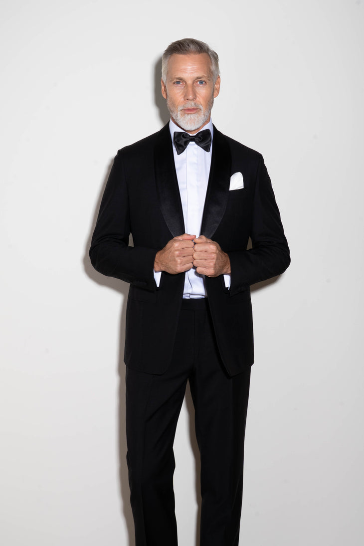 Man wearing black tuxedo trousers with white dress shirt and bow tie at formal event — Endless | Endless UAE