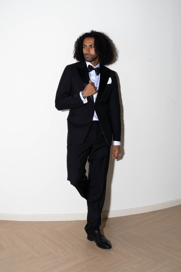 Man wearing black tuxedo trousers with white dress shirt and bow tie at formal event — Endless | Endless UAE
