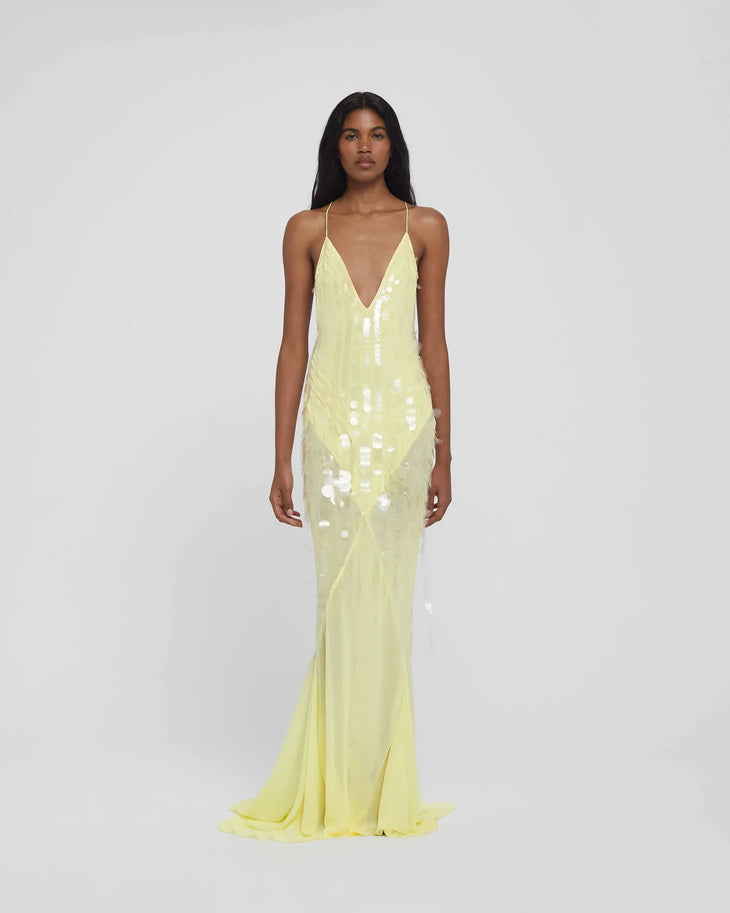 Woman wearing yellow sequined halter gown with flowing train and flower hair accessory — Rat & Boa | Endless UAE