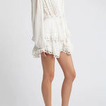 Woman wearing white eyelet cotton mini dress with long sleeves and layered skirt — LoveShackFancy | Endless UAE
