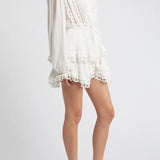 Woman wearing white eyelet cotton mini dress with long sleeves and layered skirt — LoveShackFancy | Endless UAE