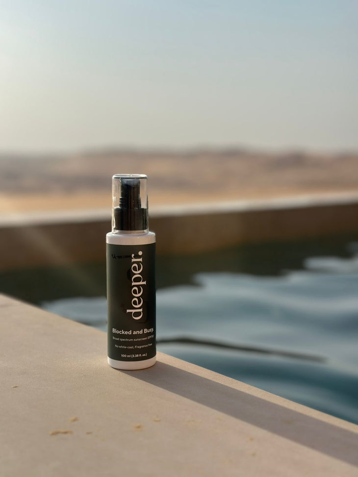 Deeper Beauty Blocked and Busy SPF 50 sunscreen bottle with pump dispenser on white surface — Deeper Beauty | Endless UAE