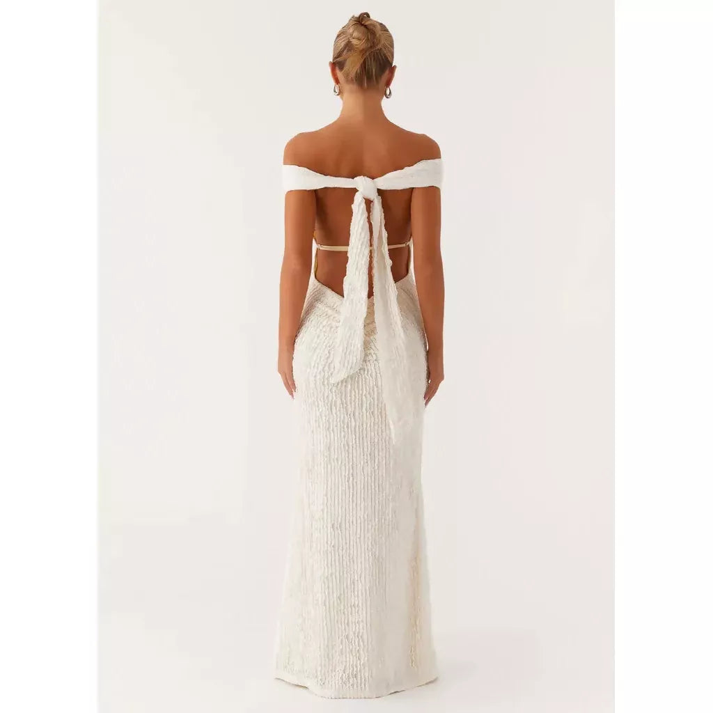 Woman wearing white off-shoulder maxi dress with open back and tie detail, rear view — Peppermayo | Endless UAE