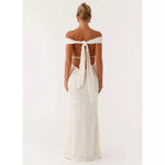 Woman wearing white off-shoulder maxi dress with open back and tie detail, rear view — Peppermayo | Endless UAE