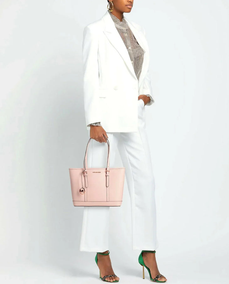 Woman in white suit carrying pink leather Michael Kors Jet Set tote bag with gold hardware and MK charm — Michael Kors | Endless UAE